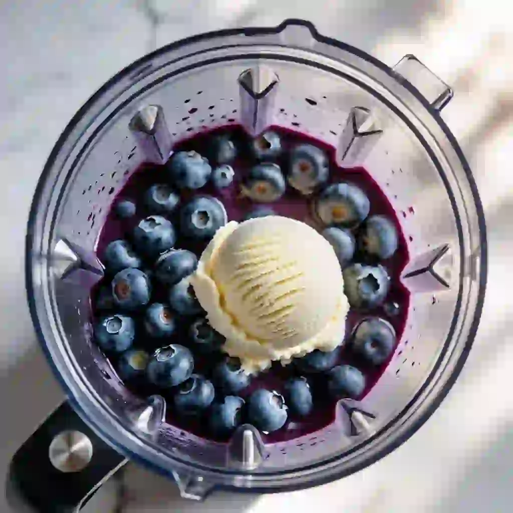 A delicious blueberry milkshake in a blender with ice cream