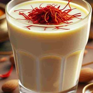 A glass of saffron almond milk, a traditional and popular drink enjoyed in India, showcasing its vibrant yellow color.